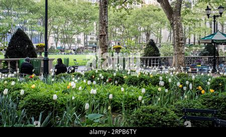 New York, New York, USA - 26 aprile 2023: Due persone sedute in un tranquillo parco di New York. Foto Stock