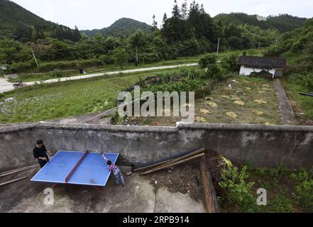 (190601) -- PECHINO, 1 giugno 2019 (Xinhua) -- Wang Beihai (L) e Chen Weiyu giocano a ping pong alla scuola elementare di Sanhe a Dabaidi Township della città di Ruijin, nella provincia di Jiangxi della Cina orientale, 7 maggio 2019. La scuola elementare di Sanhe, situata nelle montagne di Ruijin, ha un solo insegnante, Wang Beihai di 46 anni, e uno studente Chen Weiyu, un ragazzo di 9 anni di una famiglia povera. Lo studente Chen Weiyu, che viveva con sua nonna, era solito studiare in una scuola a circa 20 chilometri da casa sua. Suo nonno doveva portarlo da e per la scuola guidando un trattore ogni giorno. Lo Foto Stock