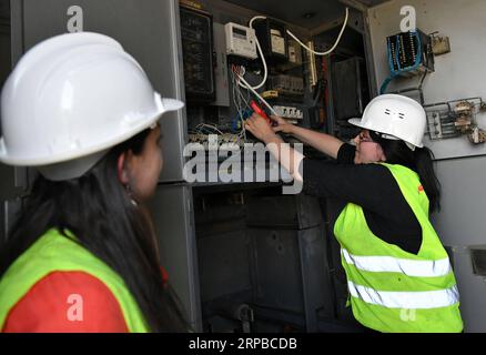 (190605) -- HOMS, 5 giugno 2019 -- le lavoratrici elettriche femminili fissano trasformatori elettrici nella provincia di Homs, Siria centrale, il 30 maggio 2019. Mentre la guerra in Siria scoppiava, le donne siriane cominciarono a impegnarsi in più posti di lavoro rispetto al normale lavoro d'ufficio e a crescere bambini, dato che un gran numero di uomini si erano Uniti all'esercito o avevano lasciato il paese per cercare rifugio. I lavori che le donne svolgono sempre più spesso comprendono la riparazione di automobili, la guida di autobus o taxi e, cosa più interessante, l'utilizzo di una gru per raggiungere le linee elettriche ad alta tensione e ripararle, nonostante tutte le sfide come l'opposizione della famiglia e la paura di h Foto Stock