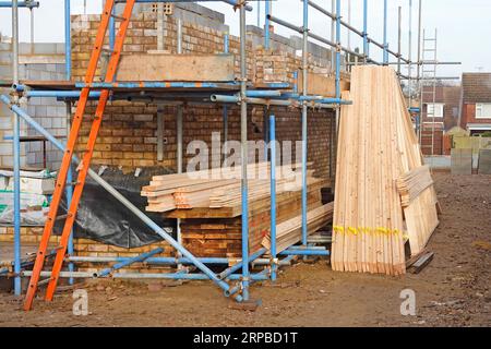 Fabbrica di travi in legno prefabbricate e trattate chimicamente fuori dal sito consegnato con travi in legno a pavimento immagazzinate pronto per la costruzione in nuova casa UK Foto Stock