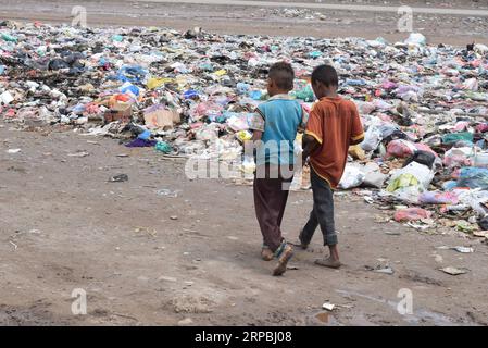 (190609) -- ADEN (YEMEN), 9 giugno 2019 -- i bambini sfollati camminano in una discarica vicino al loro campo di sfollamento nella periferia di Aden, Yemen, il 9 giugno 2019. Le forti piogge e le inondazioni hanno colpito diverse parti delle province meridionali e orientali dello Yemen domenica, lasciando almeno tre morti e molti altri feriti, hanno detto fonti di sicurezza locali. Migliaia di yemeniti sfollati interni con sede nella periferia di Aden soffrivano maggiormente per le forti piogge che danneggiarono i loro luoghi di dimora improvvisati. ) YEMEN-ADEN-SFOLLATI-PIOGGE INTENSE MURADXABDO PUBLICATIONXNOTXINXCHN Foto Stock