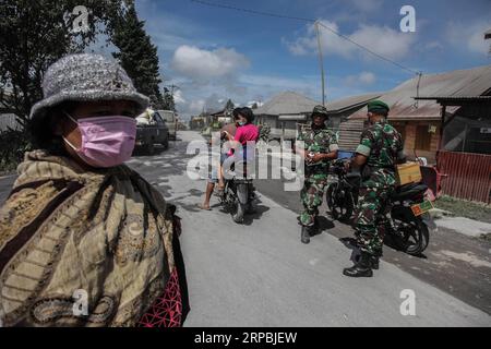 (190610) -- SUMATRA SETTENTRIONALE, 10 giugno 2019 -- le persone che indossano maschere sono viste dopo l'eruzione del vulcano Sinabung a Karo, Sumatra settentrionale, Indonesia, 10 giugno 2019. Una colonna di spessa cenere è stata spedita sette km di altezza verso il cielo dal cratere del vulcano del Monte Sinabung nell'isola di Sumatra, nell'Indonesia occidentale, domenica, ha detto l'agenzia nazionale di vulcanologia del paese. ) INDONESIA-SUMATRA SETTENTRIONALE-MONTE SINABUNG-DOPO ERUZIONE ALBERTXDAMANIK PUBLICATIONXNOTXINXCHN Foto Stock