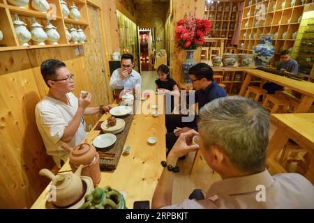 (190611) -- KUALA LUMPUR, 11 giugno 2019 (Xinhua) -- Ricky Heng (1st L) assaggia il tè con gli amici del tè nella sua casa da tè a Kuala Lumpur, Malesia, 24 maggio 2019. Ricky Heng, 51 anni, è un maestro del tè di Kuala Lumpur, Malesia. Era un fotoreporter, spesso trasportava 6 o 7 chilogrammi di attrezzature per fare 4 o 5 lavori al giorno. Quello che Ricky Heng non si aspettava è che la sua vita è stata completamente cambiata a causa del tè cinese. Dopo aver iniziato a bere il tè cinese, la vita di Ricky Heng rallentò gradualmente. Quando beve tè, dice, entra in uno stato di meditazione del tè, uno stato che rende le persone Foto Stock