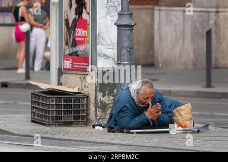 Immagine di un mendicante che implorava e pregava per le strade di Budapest. Foto Stock