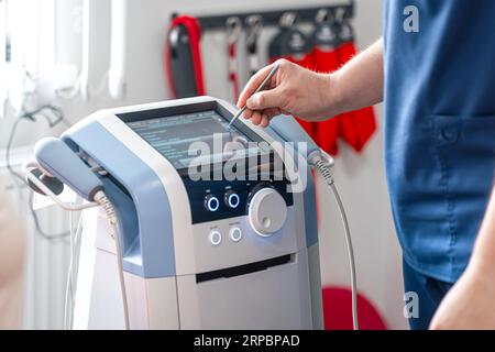 Fisioterapista medico utilizza attrezzature mediche per un trattamento efficace del dolore. Foto Stock