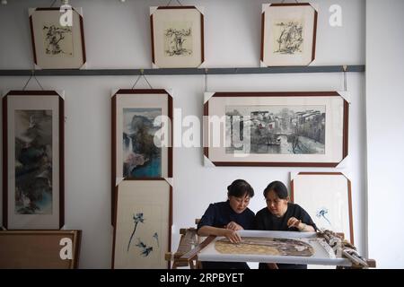 (190619) -- NANCHINO, 19 giugno 2019 (Xinhua) -- Yao Huifen (L) e sua sorella Yao Huiqin scambiano punti nel suo laboratorio nella città di Zhenhu di Suzhou, nella provincia di Jiangsu della Cina orientale, 11 giugno 2019. Il ricamo di Suzhou, uno dei quattro ricami più famosi della Cina, ha origine a Suzhou e ha una storia di oltre 2.000 anni. Noto per il suo elegante motivo, il design artistico, la raffinata lavorazione a mano e i vari punti, è stato inserito tra i patrimoni culturali immateriali nazionali della Cina nel 2006. Yao Huifen, erede rappresentativo del mestiere, nacque a Suzhou nel 1967 in una famiglia di ricami. In Foto Stock