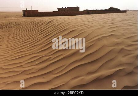 (190622) -- YINCHUAN, 22 giugno 2019 (Xinhua) -- la foto del file scattata nell'aprile 2002 mostra le case degli abitanti del villaggio circondate da dune di sabbia al Liming Village di Maerzhuang Township nella contea di Yanchi, nella regione autonoma Ningxia Hui della Cina nordoccidentale. Situata sul margine meridionale del deserto di Maowusu, la contea di Yanchi era un tempo devastata dalla povertà e soffriva di desertificazione. Ma dopo anni di sforzi, l'ambiente è stato ripristinato, e anche la contea ha scosso la povertà. (Xinhua/Liu Quanlong) CHINA-NINGXIA-YANCHI-POVERTY ELIMINATION (CN) PUBLICATIONxNOTxINxCHN Foto Stock