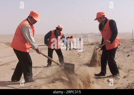 (190622) -- YINCHUAN, 22 giugno 2019 (Xinhua) -- la foto del file scattata nell'aprile 2002 mostra i lavoratori sgombrare una strada coperta di sabbia nella città di Jianerzhuang della contea di Yanchi, nella regione autonoma Ningxia Hui della Cina nordoccidentale. Situata sul margine meridionale del deserto di Maowusu, la contea di Yanchi era un tempo devastata dalla povertà e soffriva di desertificazione. Ma dopo anni di sforzi, l'ambiente è stato ripristinato, e anche la contea ha scosso la povertà. (Xinhua/Liu Quanlong) CHINA-NINGXIA-YANCHI-POVERTY ELIMINATION (CN) PUBLICATIONxNOTxINxCHN Foto Stock