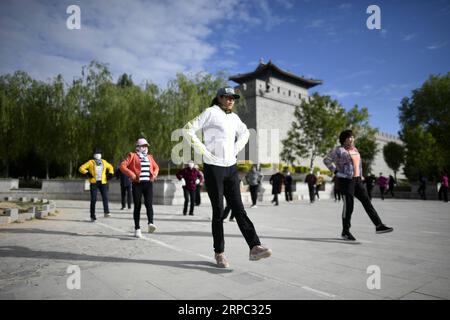 (190622) -- YINCHUAN, 22 giugno 2019 (Xinhua) -- esercitazione dei cittadini vicino alle mura della città ristrutturate nella contea di Yanchi, regione autonoma Ningxia Hui della Cina nord-occidentale, 28 maggio 2019. Situata sul margine meridionale del deserto di Maowusu, la contea di Yanchi era un tempo devastata dalla povertà e soffriva di desertificazione. Ma dopo anni di sforzi, l'ambiente è stato ripristinato, e anche la contea ha scosso la povertà. (Xinhua/Wang Peng) CHINA-NINGXIA-YANCHI-POVERTY ELIMINATION (CN) PUBLICATIONxNOTxINxCHN Foto Stock