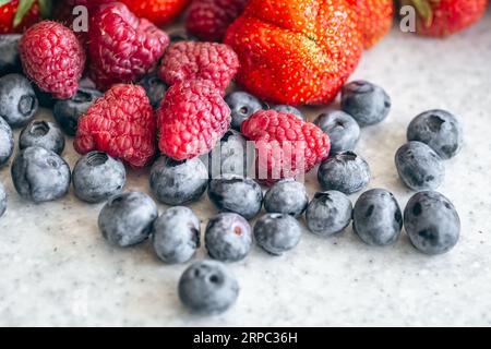Mirtilli, lamponi e fragole sul tavolo della cucina, primo piano. Foto Stock