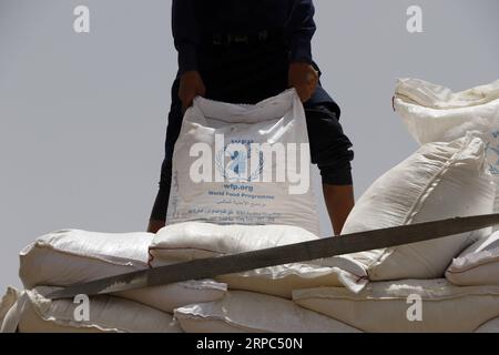 190623 -- SANAA, 23 giugno 2019 -- Un uomo tiene un sacco di farina di grano fortificata del programma alimentare Mondiale delle Nazioni Unite a Sanaa, Yemen, il 23 giugno 2019. Lunedì, David Beasley, capo del programma alimentare Mondiale delle Nazioni Unite WFP in Yemen, ha attaccato i ribelli Houthi nelle province settentrionali dello Yemen per essersi appropriati indebitamente degli aiuti. Dall'altra parte, gli Houthi, sostenuti dall'Iran, hanno accusato il WFP di fornire agli yemeniti assistenza alimentare marcio e scaduta. Tuttavia, mercoledì il WFP ha fortemente negato le affermazioni degli Houthi sui cibi marci consegnati nello Yemen, affermando di avere un forte meccanismo per controllare il foo Foto Stock