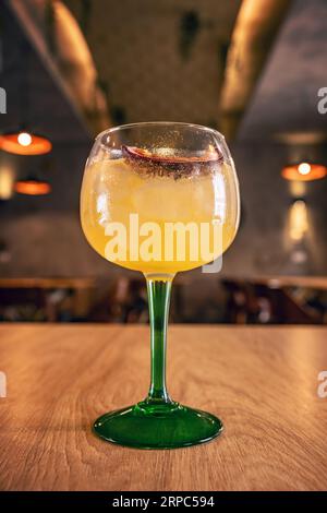 Fresco e rinfrescante cocktail estivo al frutto della passione al tavolo da bar Foto Stock