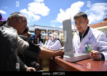 (190624) -- MAQU, 24 giugno 2019 -- il membro del team di assistenza medica Chen Zhifang(R) misura la pressione sanguigna per un residente locale nella contea di Maqu della prefettura autonoma tibetana di Gannan, provincia del Gansu della Cina nordoccidentale, il 23 giugno 2019. Gansu secondo ospedale provinciale del popolo ha inviato oltre 30 medici in quattro lotti per fornire assistenza medica nella contea di Maqu dalla fine del 2015. I medici superarono le difficoltà del mal di altitudine e del trasporto scomodo mentre curavano i pazienti sulla prateria sull'altopiano. Dopo aver servito quasi 10, 000 persone finora, l'equipe medica ha risolto il diff dei pastori Foto Stock