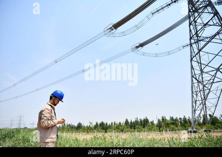 (190624) -- TIANJIN, 24 giugno 2019 -- un ingegnere gestisce un drone per ispezionare le linee elettriche ad alta tensione nel nord della Cina a Tianjin, 24 giugno 2019. ) CHINA-TIANJIN-HIGH VOLTAGE LINE-INSPECTION (CN) LIXRAN PUBLICATIONXNOTXINXCHN Foto Stock