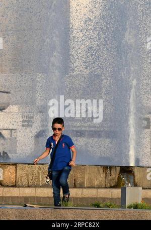 (190627) -- DAMASCO, 27 giugno 2019 -- Un ragazzo si gode il tempo vicino a una fontana in Piazza Omayyad a Damasco, Siria, il 26 giugno 2019. Le persone a Damasco soffrivano di calore poiché la temperatura era più alta del normale.) SIRIA-DAMASCO-ONDATA DI CALORE AmmarxSafarjalani PUBLICATIONxNOTxINxCHN Foto Stock