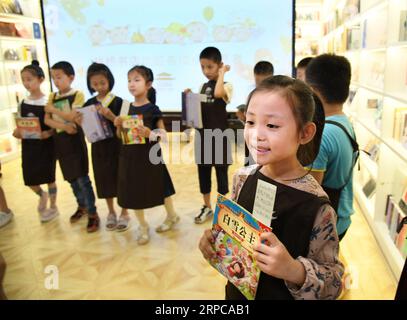 (190629) -- QINGDAO, 29 giugno 2019 -- giovani volontari selezionano libri per bambini che vivono in remote aree montuose colpite dalla povertà presso la libreria Zhanqiao di Qingdao, nello Shandong della Cina orientale, 29 giugno 2019. Più di 30 bambini sono stati addestrati come volontari nella libreria Zhanqiao. Durante le vacanze estive, saranno impegnati nella guida dei lettori, nella smistamento di libri, nelle attività di welfare pubblico e in altre attività che rientrano nella loro capacità. In cambio, viene loro concessa la priorità nel prendere in prestito libri, con alcuni dati loro come regali. ) CHINA-QINGDAO-LIBRERIA-VOLONTARI (CN) LixZiheng PUBLICATIONxNOTxINxCHN Foto Stock