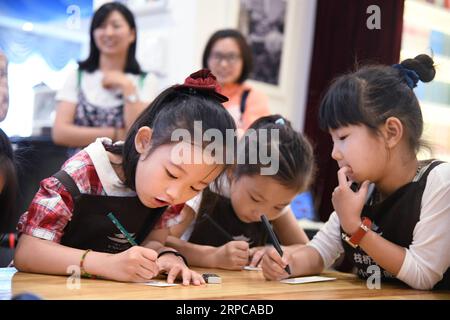 (190629) -- QINGDAO, 29 giugno 2019 -- giovani volontari scrivono ai bambini che vivono in remote aree montuose colpite dalla povertà nella libreria Zhanqiao di Qingdao, nello Shandong della Cina orientale, 29 giugno 2019. Più di 30 bambini sono stati addestrati come volontari nella libreria Zhanqiao. Durante le vacanze estive, saranno impegnati nella guida dei lettori, nella smistamento di libri, nelle attività di welfare pubblico e in altre attività che rientrano nella loro capacità. In cambio, viene loro concessa la priorità nel prendere in prestito libri, con alcuni dati loro come regali. ) CHINA-QINGDAO-LIBRERIA-VOLONTARI (CN) LixZiheng PUBLICATIONxNOTxINxCHN Foto Stock