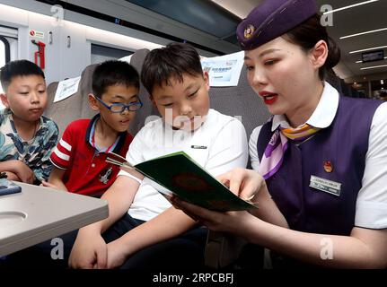 (190630) -- SHANGHAI, 30 giugno 2019 -- Attendant He Meng (R) spiega i suggerimenti per la sicurezza dei viaggi ai bambini a bordo del treno proiettile G1655 da Shanghai della Cina orientale a Xiamen, provincia del Fujian della Cina sudorientale, 30 giugno 2019. La ferrovia cinese vedrà alta stagione estiva dal 1° luglio al 31 agosto). CINA-SHANGHAI-FERROVIA-TRASPORTO ESTIVO (CN) CHENXFEI PUBLICATIONXNOTXINXCHN Foto Stock