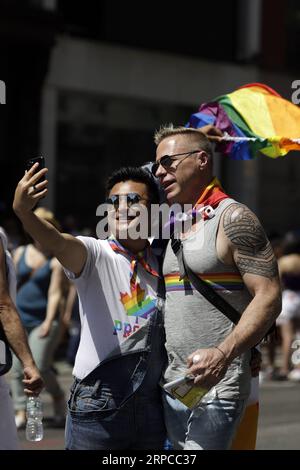 (190630) -- NEW YORK, 30 giugno 2019 -- le persone fanno selfie durante la New York City Pride Parade del 2019 a New York, negli Stati Uniti, il 30 giugno 2019. Migliaia di persone hanno partecipato alla celebrazione annuale dell'orgoglio per celebrare il 50° anniversario della rivolta di Stonewall qui di domenica. U.S.-NEW YORK-PRIDE PARADE LixMuzi PUBLICATIONxNOTxINxCHN Foto Stock
