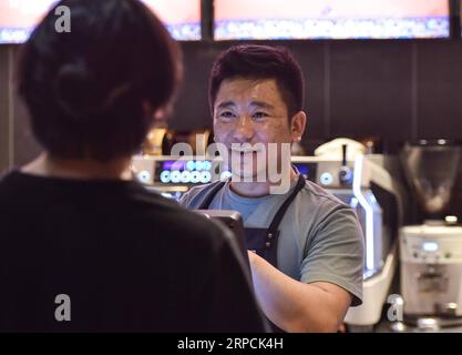 190707 -- XINING, 7 luglio 2019 -- Gonpo Cering, proprietario di un caffè del gruppo etnico tibetano, prende gli ordini dei clienti a Xining, nella provincia del Qinghai della Cina nord-occidentale, 7 luglio 2019. Cering ha familiarizzato con la cultura del caffè dopo la sua laurea al college nel 2012. L'uomo di 28 anni gestisce un caffè a Xining, che serve caffè in stile tibetano originale come latte d'orzo e burro di yak americano ai clienti desiderosi. Cresciuto in una famiglia tibetana sui pascoli, Cering dice di voler mescolare i suoi ricordi d'infanzia con i caffè e ha quindi sperimentato molto. Quando y Foto Stock