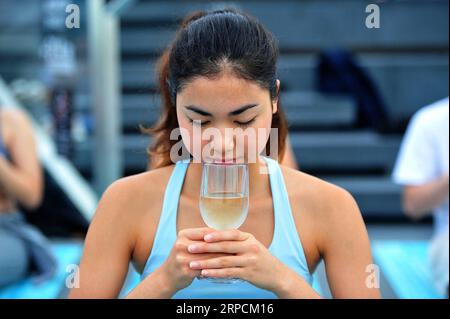 (190708) -- BANGKOK, 8 luglio 2019 -- Un appassionato di yoga partecipa alla lezione di yoga all'alba sul vino nella zona sul tetto del Mahanakhon Skywalk a Bangkok, Thailandia, 7 luglio 2019. Il Sunrise Wine yoga combina la gioia di bere vino con le tradizionali pose dello yoga, bilanciando le bevande, sorseggiando e tostando. ) THAILANDIA-BANGKOK-YOGA RachenxSageamsak PUBLICATIONxNOTxINxCHN Foto Stock