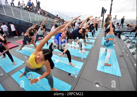 (190708) -- BANGKOK, 8 luglio 2019 -- gli appassionati di yoga assistono alla lezione di yoga all'alba presso la zona sul tetto del Mahanakhon Skywalk a Bangkok, Thailandia, 7 luglio 2019. Il Sunrise Wine yoga combina la gioia di bere vino con le tradizionali pose dello yoga, bilanciando le bevande, sorseggiando e tostando. ) THAILANDIA-BANGKOK-YOGA RachenxSageamsak PUBLICATIONxNOTxINxCHN Foto Stock