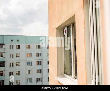 Un moderno robot aspirapolvere lavavetri lavavetri in un appartamento su un balcone. Vista dall'esterno dalla strada. Sicurezza dalle cadute dall'alto, automati Foto Stock