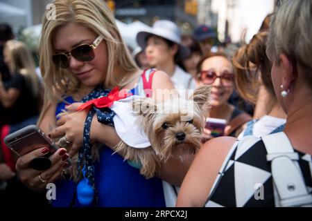 (190714) -- NEW YORK, 14 luglio 2019 (Xinhua) -- Una donna che porta un cane vestito partecipa alla celebrazione del giorno della Bastiglia dell'Istituto francese Alliance Francaise (FIAF) a New York, negli Stati Uniti, 14 luglio 2019. Il giorno della Bastiglia, noto anche come giornata nazionale francese, commemora l'inizio della Rivoluzione francese e l'assalto della Bastiglia a Parigi il 14 luglio 1789. (Xinhua/Michael Nagle) U.S.-NEW YORK-BASTILLE DAY CELEBRATION PUBLICATIONxNOTxINxCHN Foto Stock