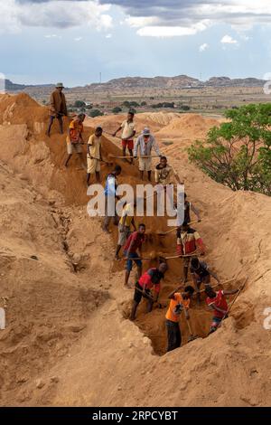 Ilakaka, Madagascar - 24 novembre 2022 - lavorando in tandem, i minatori hanno unito i loro sforzi, sparando terra e cercando meticolosamente gemme di zaffiro, Foto Stock