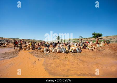 Ihosy, Ilakaka, Madagascar - 20 novembre 2022: La gente del posto smina per gemme e pan per l'oro in un fiume. La città è un importante centro di produzione di zaffiro Foto Stock