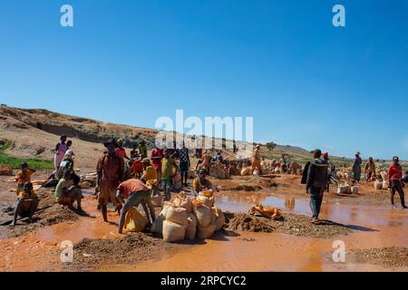 Ihosy, Ilakaka, Madagascar - 20 novembre 2022: La gente del posto smina per gemme e pan per l'oro in un fiume. La città è un importante centro di produzione di zaffiro Foto Stock