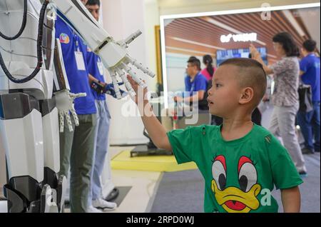 (190718) -- PECHINO, 18 luglio 2019 -- Un bambino stringe la mano con un robot durante un'esposizione internazionale di Internet of Things (IoT) mobile a Yingtan, nella provincia del Jiangxi della Cina orientale, 18 luglio 2019. ) Xinhua titoli: Tutte le cose connesse: La tecnologia aiuta il cinese a vivere in modo più intelligente ZhouxMi PUBLICATIONxNOTxINxCHN Foto Stock