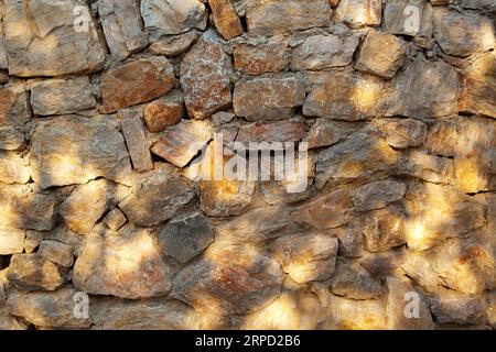 Robusto muro in pietra con taglio blu e beige realizzato a Datca, Turchia, ottimo per sfondi, allineato senza cuciture Foto Stock