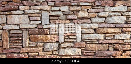 Robusto muro in pietra con taglio blu e beige realizzato a Datca, Turchia, ottimo per sfondi, allineato senza cuciture Foto Stock