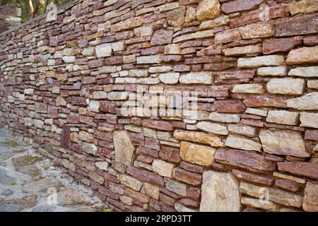 Robusto muro in pietra con taglio blu e beige realizzato a Datca, Turchia, ottimo per sfondi, allineato senza cuciture Foto Stock