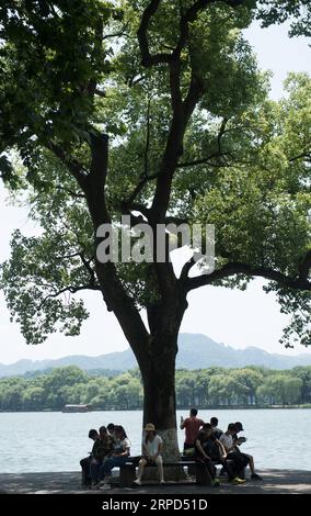 (190723) -- HANGZHOU, 23 luglio 2019 -- i turisti riposano vicino al Lago Occidentale a Hangzhou, nella provincia di Zhejiang nella Cina orientale, 23 luglio 2019. L'ondata di calore continua a colpire Hangzhou fino all'inizio di agosto.) CHINA-ZHEJIANG-HANGZHOU-HEAT WAVE (CN) WENGXXINYANG PUBLICATIONXNOTXINXCHN Foto Stock