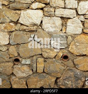 Robusto muro in pietra con taglio blu e beige realizzato a Datca, Turchia, ottimo per sfondi, allineato senza cuciture Foto Stock