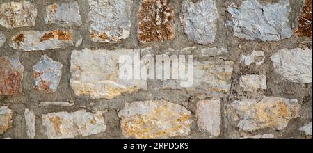 Robusto muro in pietra con taglio blu e beige realizzato a Datca, Turchia, ottimo per sfondi, allineato senza cuciture Foto Stock