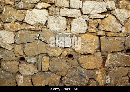 Robusto muro in pietra con taglio blu e beige realizzato a Datca, Turchia, ottimo per sfondi, allineato senza cuciture Foto Stock