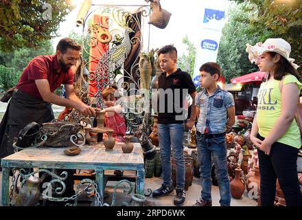 (190725) -- DAMASCO, 25 luglio 2019 -- i bambini provano il lavoro di ceramica durante un festival di intrattenimento chiamato Sham (Damasco) ci riunisce a Damasco, Siria, 24 luglio 2019. Il festival di un mese comprende spettacoli folcloristici, giochi per bambini e degustazioni di cibo, tra le altre attività. (Foto di /Xinhua) SIRIA-DAMASCO-ENTERTAINMENT FESTIVAL AmmarxSafarjalani PUBLICATIONxNOTxINxCHN Foto Stock