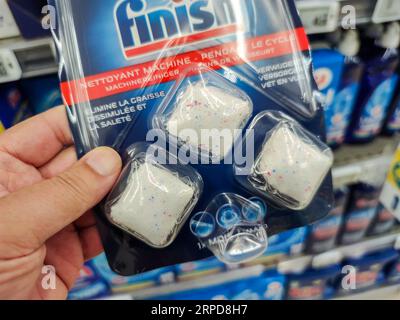 Puilboreau, Francia - 14 ottobre 2020: Shopper Holding a dishwashing deterent and Regenerating Salt Section Tabs Foto Stock