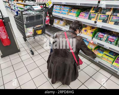Puilboreau, Francia - 14 ottobre 2020: Vista posteriore della donna che sceglie Sponge in un supermercato francese Foto Stock