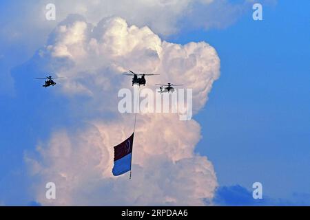 (190728) -- PECHINO, 28 luglio 2019 -- Un elicottero della Republic of Singapore Air Force batte una bandiera nazionale durante le prove della National Day Parade a Singapore il 27 luglio 2019. ) XINHUA FOTO DEL GIORNO ThenxChihxWey PUBLICATIONxNOTxINxCHN Foto Stock