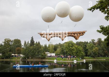 (190801) -- MOSCA, 1 agosto 2019 (Xinhua) -- Un ponte volante fatto di cartone e nastro adesivo è visibile nel parco Ostankino a Mosca, in Russia, il 1 agosto 2019. Un ponte volante lungo 18 metri realizzato in cartone e nastro per condotti è stato assemblato e installato giovedì nel parco Ostankino di Mosca. Il ponte fu sollevato in aria con l'aiuto di tre palloncini riempiti di elio. (Foto di Maxim Chernavsky/Xinhua) RUSSIA-MOSCA-FLYING BRIDGE PUBLICATIONxNOTxINxCHN Foto Stock