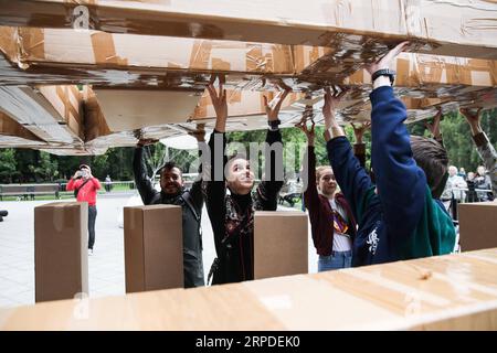 (190801) -- MOSCA, 1 agosto 2019 (Xinhua) -- i volontari assemblano un ponte di cartone e nastro adesivo nel parco Ostankino a Mosca, in Russia, il 1 agosto 2019. Un ponte volante lungo 18 metri realizzato in cartone e nastro per condotti è stato assemblato e installato giovedì nel parco Ostankino di Mosca. Il ponte fu sollevato in aria con l'aiuto di tre palloncini riempiti di elio. (Foto di Maxim Chernavsky/Xinhua) RUSSIA-MOSCA-FLYING BRIDGE PUBLICATIONxNOTxINxCHN Foto Stock