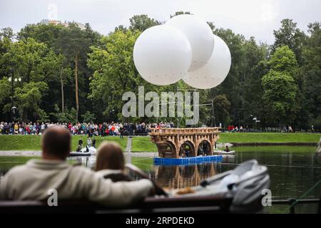 (190801) -- MOSCA, 1 agosto 2019 (Xinhua) -- la gente guarda un ponte volante fatto di cartone e nastro adesivo nel parco Ostankino a Mosca, in Russia, il 1 agosto 2019. Un ponte volante lungo 18 metri realizzato in cartone e nastro per condotti è stato assemblato e installato giovedì nel parco Ostankino di Mosca. Il ponte fu sollevato in aria con l'aiuto di tre palloncini riempiti di elio. (Foto di Maxim Chernavsky/Xinhua) RUSSIA-MOSCA-FLYING BRIDGE PUBLICATIONxNOTxINxCHN Foto Stock