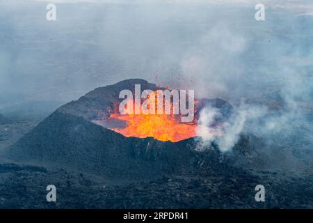 Vista ravvicinata del cono di spruzzi con lava di fessura vicino al colle Litli-Hrútur durante l'eruzione del 2023 vicino alla montagna Fagradalsfjall, vulcano a dell'Islanda Foto Stock