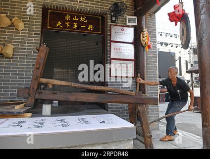 (190810) -- ANYI, 10 agosto 2019 -- Un membro del personale prepara gli spaghetti di riso alla via degli spuntini in stile Jiangxi nel villaggio di Shuinan, contea di Anyi, provincia orientale dello Jiangxi della Cina, 8 agosto 2019. Shuinan Village della contea di Anyi è un antico villaggio con una storia di oltre mille anni. La strada degli spuntini in stile Jiangxi del villaggio, aperta il 2 agosto di quest'anno, ospita 120 negozi di spuntini con 76 varietà di spuntini e piatti speciali da 11 aree della provincia di Jiangxi. La bellezza del paesaggio e la delicatezza del cibo hanno attirato un gran numero di visitatori ogni giorno. Promuovere ulteriormente l'economia locale, Foto Stock