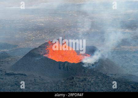 Vista ravvicinata del cono di spruzzi con lava di fessura vicino al colle Litli-Hrútur durante l'eruzione del 2023 vicino alla montagna Fagradalsfjall, vulcano a dell'Islanda Foto Stock