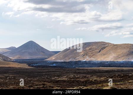 Vista panoramica sul paesaggio e sui fumosi campi di lava vicino alla fessura di Litli-Hrútur durante l'eruzione del 2023 vicino alla montagna Fagradalsfjall, Icela Foto Stock
